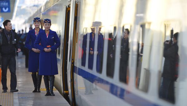 Train conductors stand outside the cabin of a bullet train - Sputnik International