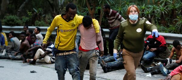African migrants help each other as they arrive at the CETI, the short-stay immigrant centre, after crossing the border from Morocco to Spain's North African enclave of Ceuta, Spain, February 17, 2017 - Sputnik International