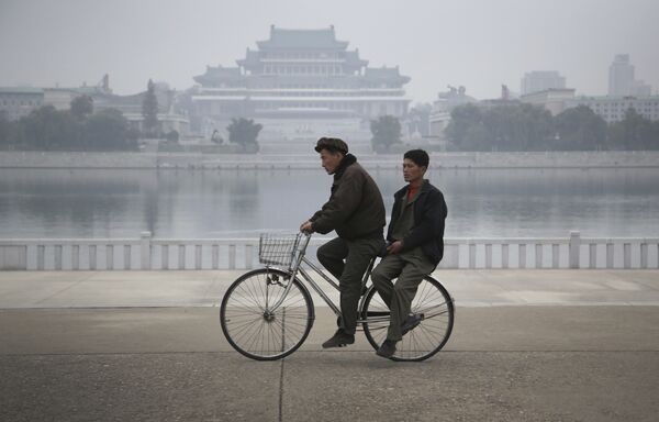 North Korean men ride their bicycle along the Taedong River where the Kim Il Sung Square and the Grand People's Study House are seen on the other side in Pyongyang, North Korea on Sunday, Oct. 16, 2016 North Korean men ride their bicycle along the Taedong River where the Kim Il Sung Square and the Grand People's Study House are seen on the other side in Pyongyang, North Korea on Sunday, Oct. 16, 2016 - Sputnik International