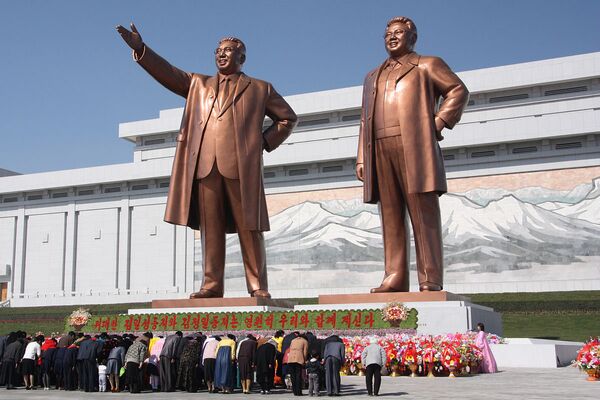 North Koreans bowing to the statues of Kim Jong-il and his father, Kim Il-sung, at the Mansu Hill Grand Monument North Koreans bowing to the statues of Kim Jong-il and his father, Kim Il-sung, at the Mansu Hill Grand Monument - Sputnik International