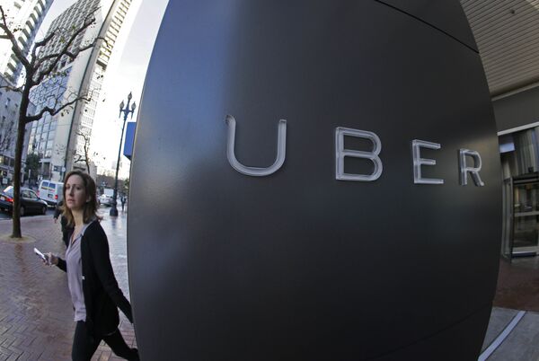In this file photo taken Tuesday, Dec. 16, 2014, a woman walks past the company logo of the internet car service, Uber, in San Francisco, USA. In this file photo taken Tuesday, Dec. 16, 2014, a woman walks past the company logo of the internet car service, Uber, in San Francisco, USA. - Sputnik International
