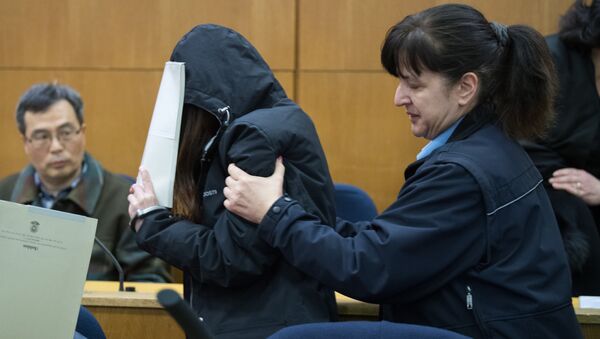 One of the main defendants covers the face as she enters the courtroom for the trial on charges of exorcism at court in Frankfurt am Main, on February 20, 2017 - Sputnik International