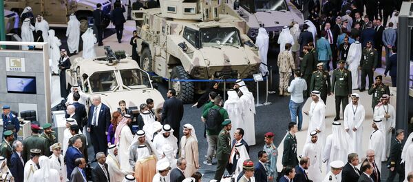 A picture taken on February 19, 2017 shows a general view of visitors walking in a showroom displaying armoured military vehicles during the opening of the International Defence Exhibition and Conference (IDEX) in the Emirati capital Abu Dhabi - Sputnik International