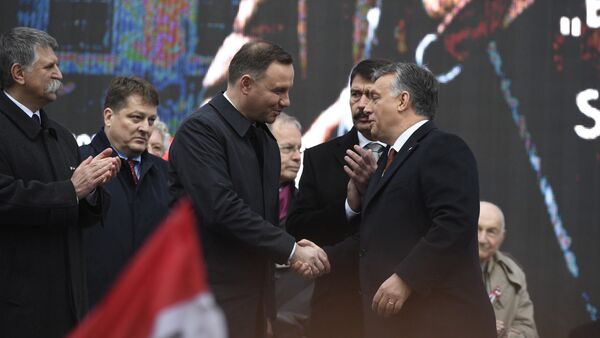 Polish President Andrzej Duda, center left, is welcomed by Hungarian Prime Minister Viktor Orban on the podium as Hungarian President Janos Ader, second right, and Speaker of the Hungarian Parliament Laszlo Kover, left, applaud during the state commemoration ceremony of the 1956 Hungarian revolution and freedom fight against communism and Soviet rule in front of the Parliament building in downtown Budapest, Hungary, Sunday, Oct. 23, 2016 - Sputnik International