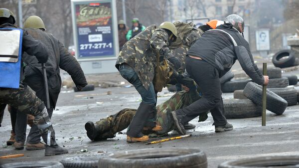 Anti-government protestors evacuate a comrade wouned by a sniper during clashes with the police in the center of Kiev on February 20, 2014 - Sputnik International