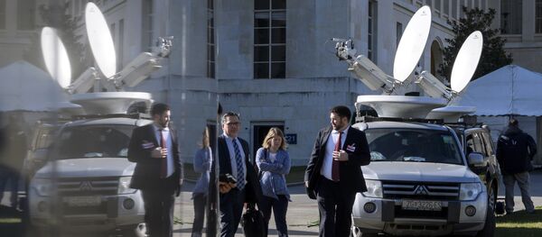 People walk past trucks with satellite dish on the eve of resumption of peace talks on Syria, on February 22, 2017 at the United Nations offices in Geneva - Sputnik International