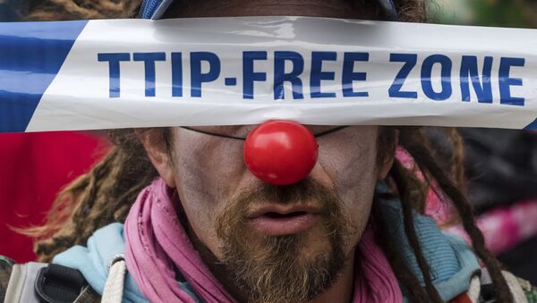 A man covers his eyes with a banner as he protests against international trade agreements TTIP and CETA in front of EU headquarters in Brussels on Thursday, Oct. 27, 2016 - Sputnik International