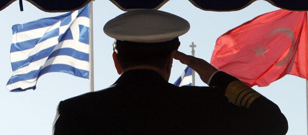 Greece's military Adm. Panagiotis Chinofotis salutes during the Turkish national anthem as the Greek, left, and Turkish flags wave at the Greek Defense Ministry in Athens on Thursday, Nov. 2, 2006 - Sputnik International