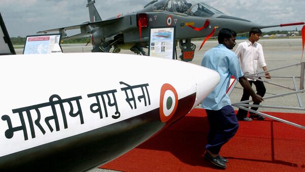 Workers of the Hindustan Aeronautics Limited (HAL) walk past a Lakshya (unmanned aerial vehicle) carrying a display board as Jaguar aircraft are on display at theHindustan Aeronautics Limited (HAL) airport in Bangalore - Sputnik International
