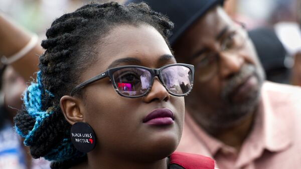 A young woman wears earrings with the slogan Black Lives Matter printed on them during the dedication and opening ceremony of the Smithsonian's National Museum of African American History and Culture in Washington, Saturday, Sept. 24, 2016. - Sputnik International