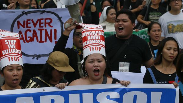 Protesters gather at the People Power Monument to mark the 31st anniversary of the near-bloodless revolt that toppled the 20-year-rule of the late dictator Ferdinand Marcos Saturday, Feb. 25, 2017, in suburban Mandaluyong city northeast of Manila, Philippines. The left-wing and pro-democracy activists warned about the current president's dictatorial tendencies and condemn his decision to allow Marcos to be buried at a heroes' cemetery. The banner reads: Abuse! - Sputnik International