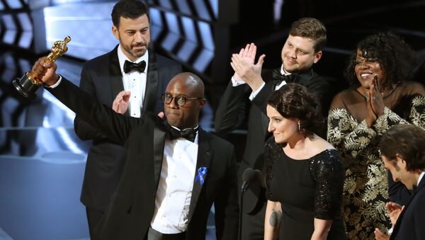 89th Academy Awards - Oscars Awards Show - Hollywood, California, U.S. - 26/02/17 - Writer and Director Barry Jenkins of Moonlight holds up the Best Picture Oscar in front of host Jimmy Kimmel (rear) as he stands with Producer Adele Romanski (R). - Sputnik International