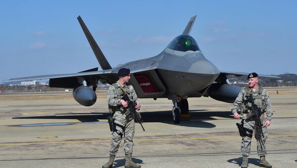 US soldiers stand guard near a US F-22 stealth fighter at the Osan Air Base in Pyeongtaek, south of Seoul, on February 17, 2016. - Sputnik International