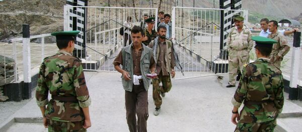Tajik border guards checking identification documents of people crossing the Tajik-Afghan border on a bridge across the Panj River outside the city of Panj Tajik border guards checking identification documents of people crossing the Tajik-Afghan border on a bridge across the Panj River outside the city of Panj - Sputnik International