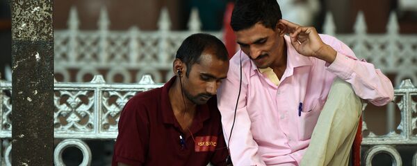 Indian commuters use their smartphones following the introduction of a new free Wi-Fi Internet service in Mumbai's central railway station on January 22, 2016 - Sputnik International