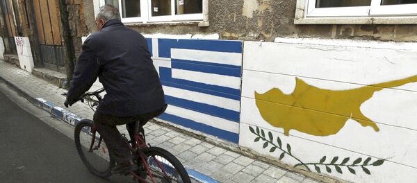 A man passes with a bicycle outside of a Greek Cypriot guard post with Cyprus', right, and Greece' flags painted on the wall in central divided capital Nicosia in the eastern Mediterranean island of Cyprus, on Thursday, Feb. 16, 2017 - Sputnik International