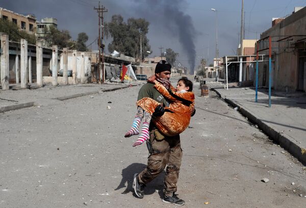 An Iraqi special forces soldier carries a woman injured during a battle between Iraqi forces and Islamic State fighters in Mosul, Iraq February 28, 2017 An Iraqi special forces soldier carries a woman injured during a battle between Iraqi forces and Islamic State fighters in Mosul, Iraq February 28, 2017 - Sputnik International