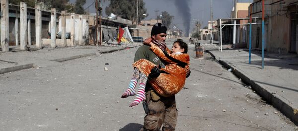 An Iraqi special forces soldier carries a woman injured during a battle between Iraqi forces and Islamic State fighters in Mosul, Iraq February 28, 2017 - Sputnik International