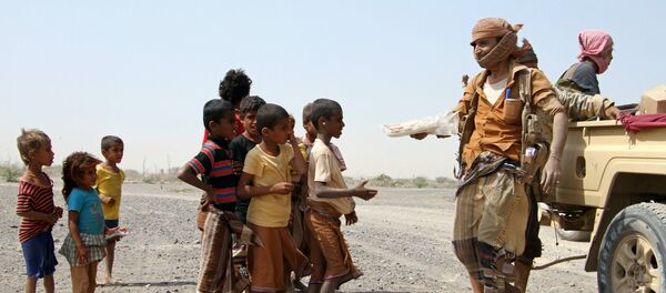 Pro-government fighters give food to Yemeni children on the road leading to the southwestern port city of Mokha on January 26, 2017 - Sputnik International