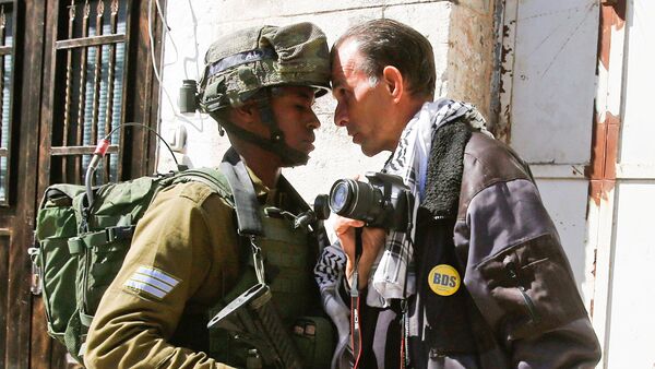 A foreign activist argues with an Israeli soldier during a protest in the West Bank city of Hebron February 24, 2017 - Sputnik International