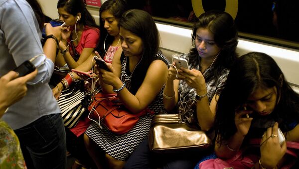 Indian women use their smartphones as they travel in the metro carriage reserved for women in New Delhi on July 14, 2015 - Sputnik International