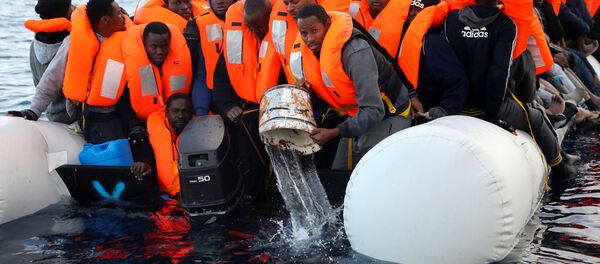 Sub-saharan migrants are seen aboard an overcrowded raft, as one of them uses a bucket to remove water from the raft, during a rescue operation by the Spanish NGO Proactiva Open Arms in the central Mediterranean Sea, north of the coastal Libyan city of Sabratha, February 3, 2017 Sub-saharan migrants are seen aboard an overcrowded raft, as one of them uses a bucket to remove water from the raft, during a rescue operation by the Spanish NGO Proactiva Open Arms in the central Mediterranean Sea, north of the coastal Libyan city of Sabratha, February 3, 2017 - Sputnik International