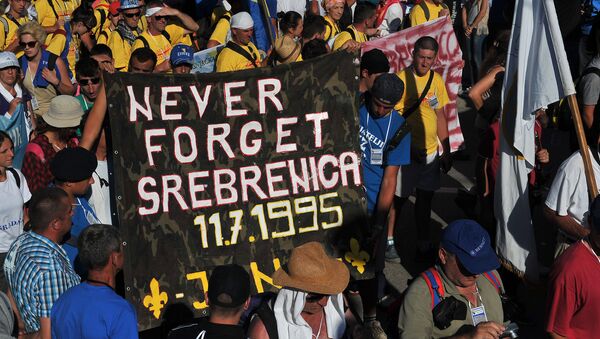 Bosnian protesters hold a banner reading 'never forget Srebrenica' during the Srebrenica Peace March near the city center of Srebrenica on July 10, 2015 - Sputnik International