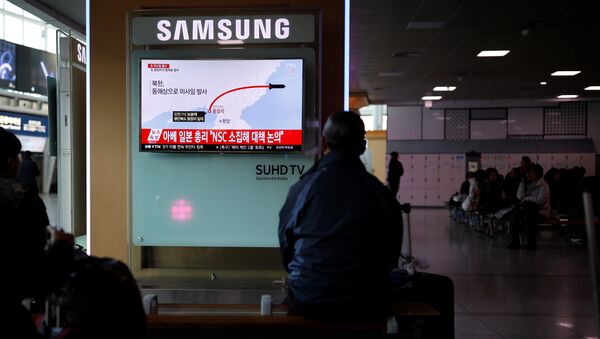 Passengers watch a television broadcasting a news report on North Korea firing ballistic missiles, at a railway station in Seoul, South Korea, March 6, 2017. - Sputnik International