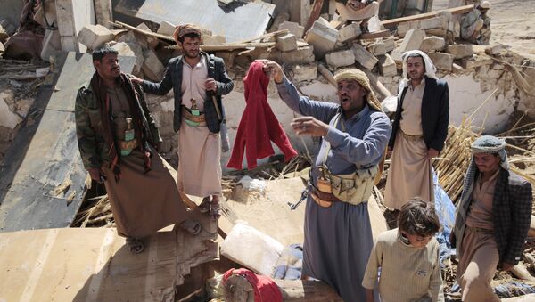 A man center, holds house destroyed by a Saudi-led airstrikes in outskirts of Sanaa, Yemen, Thursday, Feb. 16, 2017. - Sputnik International