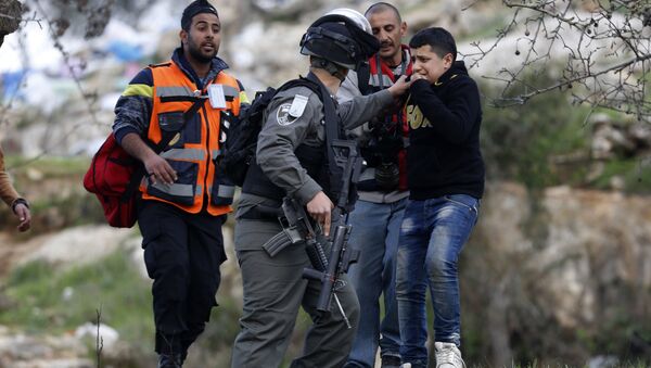 An Israeli border policeman arrests a young boy during clashes, following a protest over the death of Palestinian militant Basil al-Araj by Israeli forces early Monday, in front of the Israeli Ofer prison, near the West Bank city of Ramallah, Tuesday, March 7, 2017 - Sputnik International