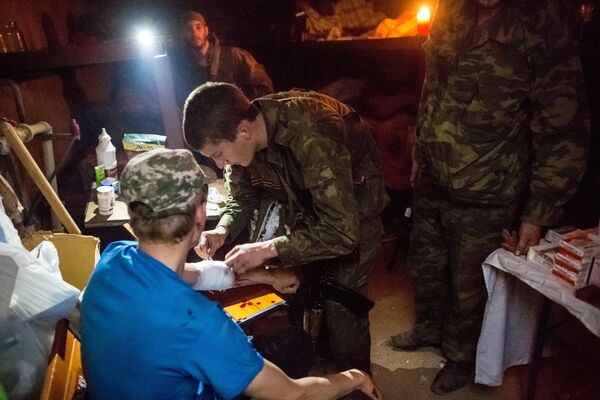 A member of the people's self-defense gives first aid to a person who wounded during a tank attack of the Ukrainian army on Semyonovka village - Sputnik International