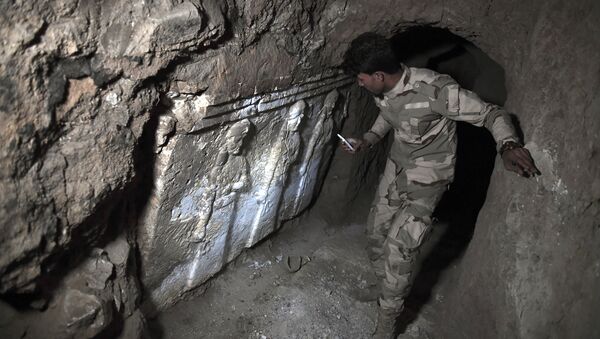 A member of the Iraqi troops stands next to archeological findings inside an underground tunnel in east Mosul on March 6, 2017 - Sputnik International