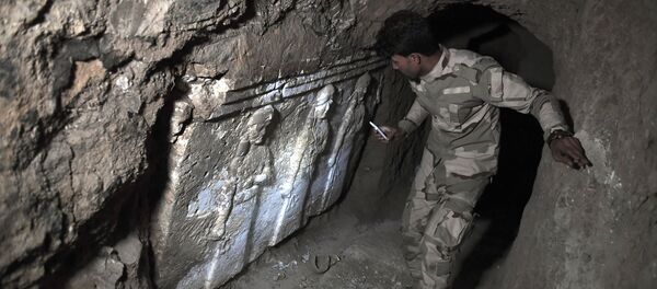 A member of the Iraqi troops stands next to archeological findings inside an underground tunnel in east Mosul on March 6, 2017 A member of the Iraqi troops stands next to archeological findings inside an underground tunnel in east Mosul on March 6, 2017 - Sputnik International