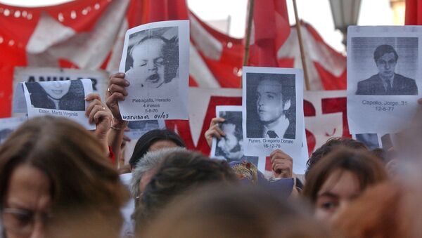 Relatives of Argentine disappeared during the Dirty War hold their photos in front of the Congress in Buenos Aires, Argentina Thursday. Augus 12, 2003. - Sputnik International