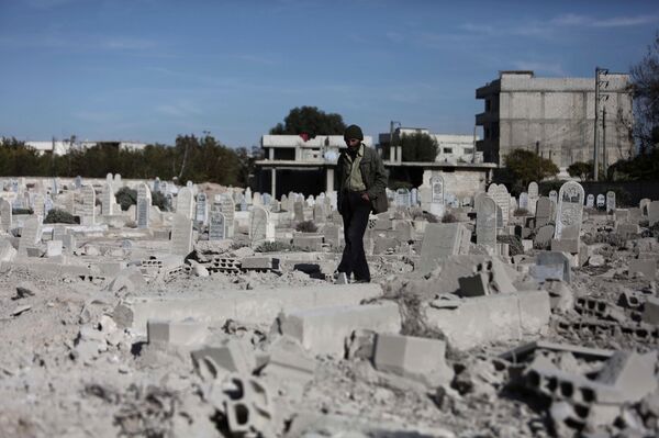 A man walks in a graveyard near destroyed graves in a neighbourhood heavily damaged by air strikes in the village of Deir al-Asafir in the rebel-held region of Eastern Ghouta, on the outskirts of the Syrian capital Damascus (File) A man walks in a graveyard near destroyed graves in a neighbourhood heavily damaged by air strikes in the village of Deir al-Asafir in the rebel-held region of Eastern Ghouta, on the outskirts of the Syrian capital Damascus (File) - Sputnik International