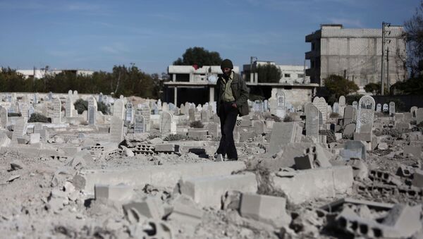 A man walks in a graveyard near destroyed graves in a neighbourhood heavily damaged by air strikes in the village of Deir al-Asafir in the rebel-held region of Eastern Ghouta, on the outskirts of the Syrian capital Damascus (File) - Sputnik International
