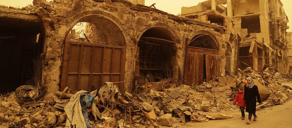 Syrian girls walk past destruction during a sandstorm in the once rebel-held Bab al-Nasr neighbourhood in the old part of Aleppo on March 10, 2017 - Sputnik International
