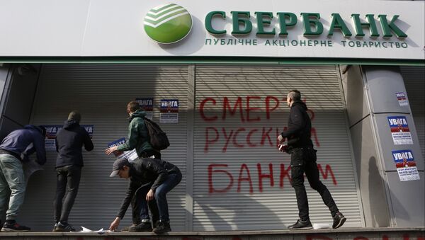 Radicals in front of a Sberbank branch in Kiev, putting up posters which read Attention! This is a bank of an aggressor country. It will be closed. Urgently withdraw your money!, during a protest. Graffiti reads Death to Russian banks. March 10, 2017 - Sputnik International