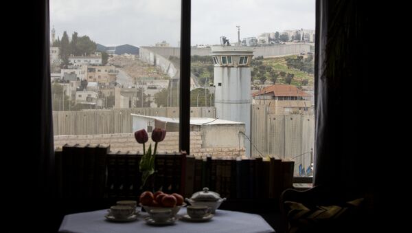 An Israeli security watch tower is seen from one of the rooms of the The Walled Off Hotel in the West Bank city of Bethlehem, Friday, March 3, 2017. - Sputnik International