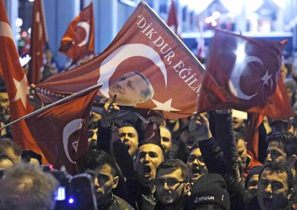 Demonstrators with banners of Turkish President Recep Tayyip Erdogan gather outsidethe Turkish consulate to welcome the Turkish Family Minister Fatma Betul Sayan Kaya, who decided to travel to Rotterdam by land after Turkish Foreign Minister Mevlut Cavusoglu's flight was barred from landing by the Dutch government, in Rotterdam, Netherlands March 11, 2017. Demonstrators with banners of Turkish President Recep Tayyip Erdogan gather outsidethe Turkish consulate to welcome the Turkish Family Minister Fatma Betul Sayan Kaya, who decided to travel to Rotterdam by land after Turkish Foreign Minister Mevlut Cavusoglu's flight was barred from landing by the Dutch government, in Rotterdam, Netherlands March 11, 2017. - Sputnik International