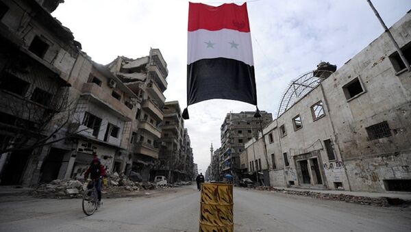 A Syrian national flag hangs in a damaged neighbourhood in Aleppo, Syria - Sputnik International