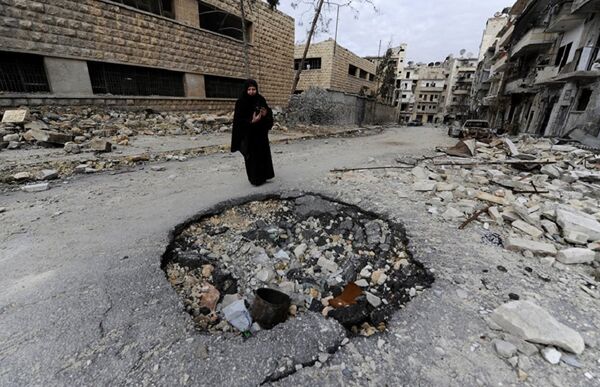 Syrian woman walks past a destroyed building in Aleppo - Sputnik International