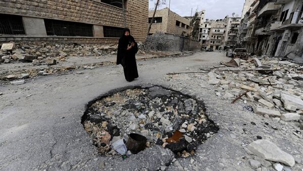A Syrian woman walks past a destroyed building in Aleppo. File photo - Sputnik International