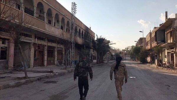 Soldiers walk past buildings destroyed during combat activities in the residential part of Ancient Palmyra in Homs Governorate, Syria - Sputnik International