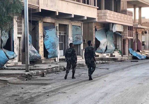 Soldiers walk past buildings destroyed during combat activities in the residential part of Ancient Palmyra in Homs Governorate, Syria - Sputnik International