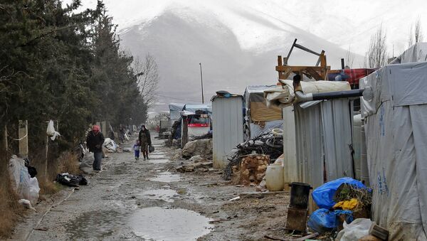 Syrian refugees walking at an unofficial refugee camp near a snow covered mountain in the village of Deir Zannoun in Lebanon's Bekaa valley. - Sputnik International