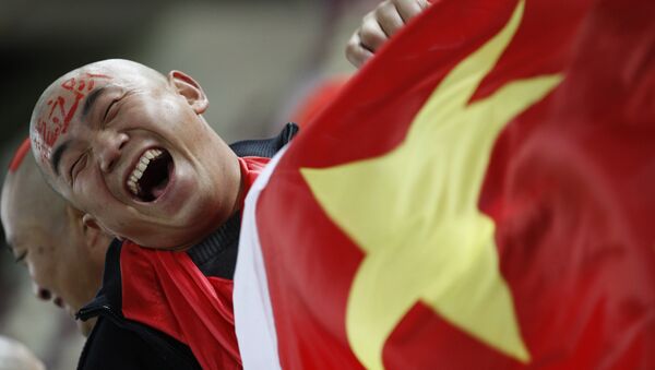 In this Wednesday, Jan. 12, 2011, file photo, a Chinese soccer fan cheers for his team before their AFC Asian Cup group A soccer match against Qatar in Doha, Qatar. - Sputnik International