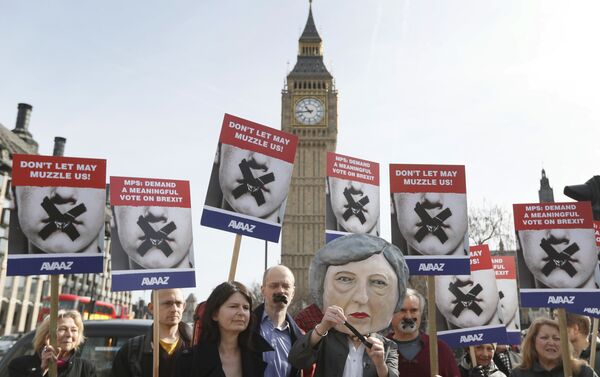 Demonstrators, one dressed in a Theresa May puppet head pose near parliament in London - Sputnik International