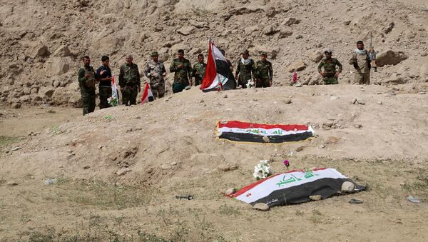 Iraqi security forces and allied Shiite militiamen pray at the site of a mass grave (file) - Sputnik International