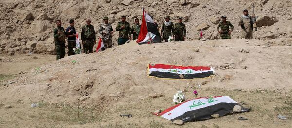 Iraqi security forces and allied Shiite militiamen pray at the site of a mass grave (file) Iraqi security forces and allied Shiite militiamen pray at the site of a mass grave (file) - Sputnik International